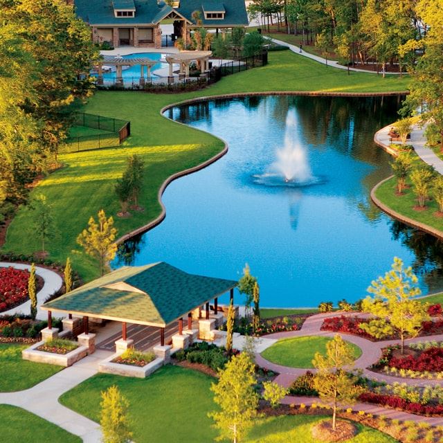 Aerial of a community pond with water fountain in it and gazebo in the foreground