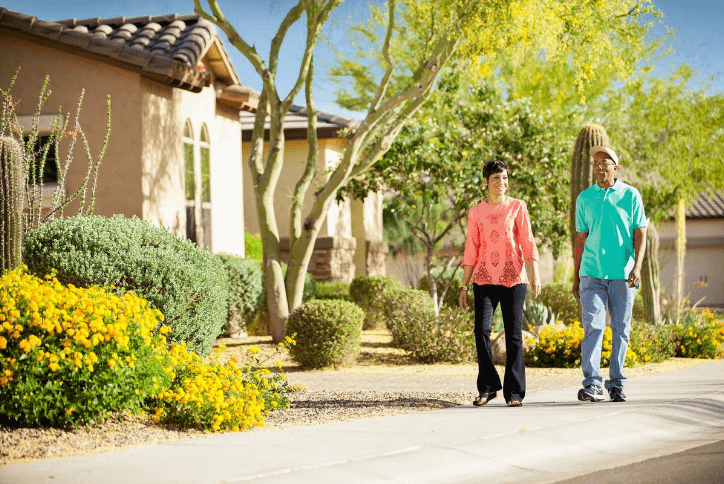 Couple walking in front of desert landscape and homes