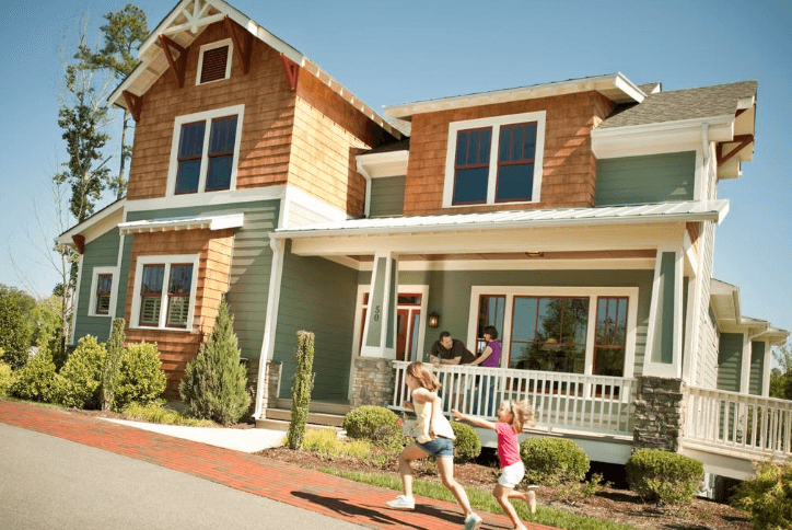 New construction home at Briar Chapel with girls running out front and couple on the porch