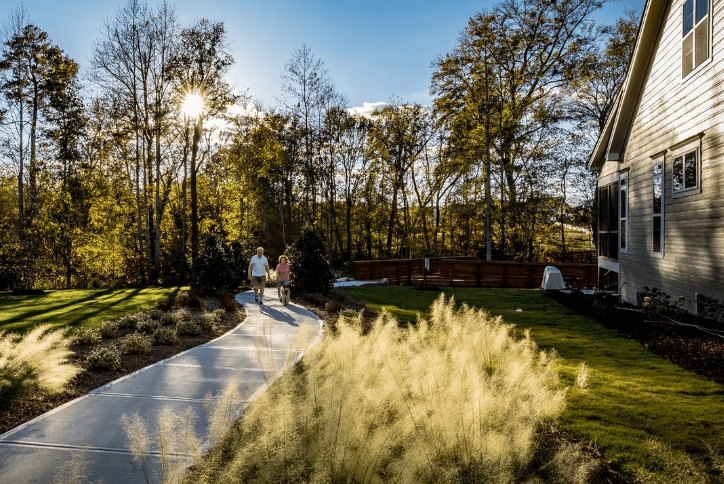 Couple and dog walking on paved trail at Wendell Falls