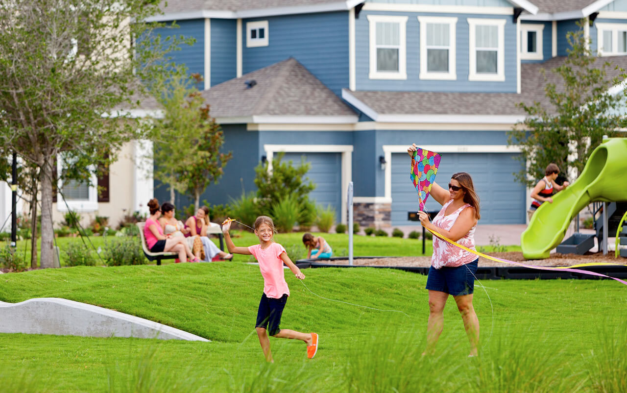 Daughter and mom playing with kite in park