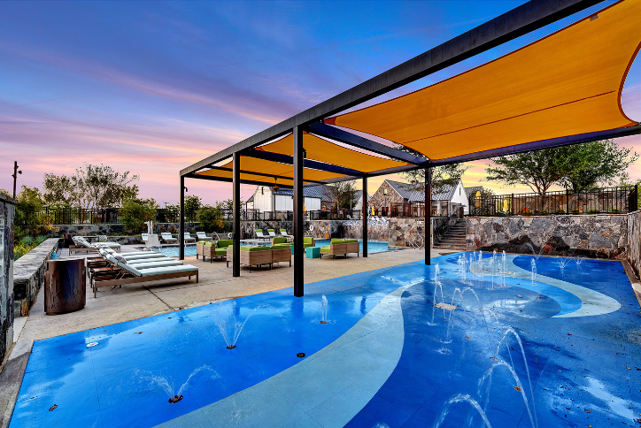 Splash Pad and pool with shade structure and lounge chairs at The Grove Frisco